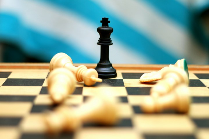 チェス盤の上の白い駒はすべて倒れました；黒い駒の王が立っています